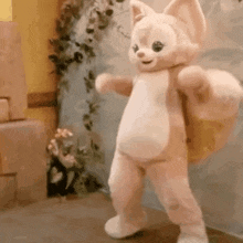 a stuffed animal is dancing in a room with a backpack on its back .