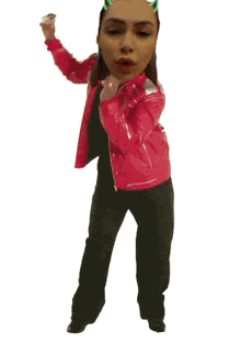 a woman wearing a pink jacket and black pants