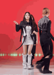 a woman in a white dress and white boots is dancing