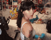 a woman with a tattoo on her arm is sitting on a bed in front of a microphone
