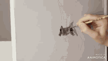 a person is drawing a rabbit on a piece of paper with the words made in animotica below it