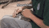 a man is petting a small rabbit on his lap .