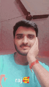 a man with a beard wearing a blue shirt that says raj