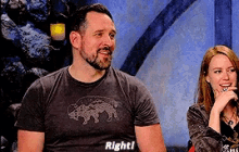 a man wearing a shirt that says right is sitting next to a woman speaking into a microphone