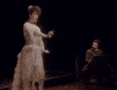 a woman in a white dress is dancing on stage