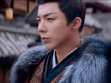 a man wearing a blue fur coat and a kimono