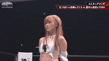 a female wrestler stands in front of a sign that says entert