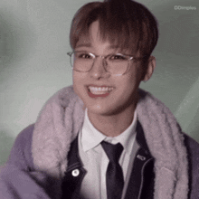 a young man wearing glasses and a purple jacket