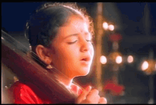 a little girl in a red dress is singing