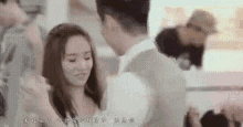 a man and a woman are standing next to each other in a room .