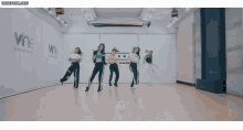 a group of girls are dancing in front of a wall that says number