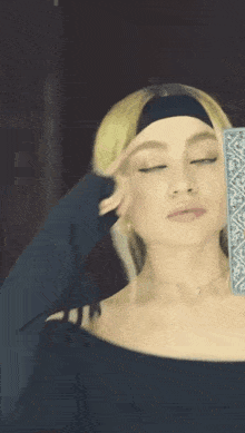 a woman wearing a headband is taking a selfie in front of a mirror .