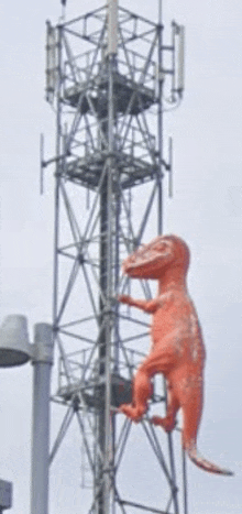 a statue of a dinosaur is hanging from a telephone pole
