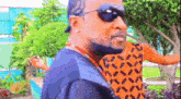 a man wearing sunglasses and a hat is standing next to a woman .