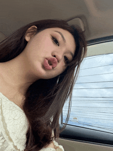 a woman is making a funny face in a car with a sticker on the window that says ' toyota ' on it