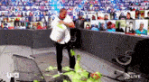 a man in a white shirt is standing next to a man covered in slime .