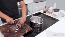 a man is cutting vegetables on a wooden cutting board in front of a pot on a stove made in animatica
