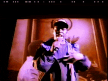 a man in a baseball cap is holding a microphone and pointing at the camera