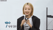 a woman wearing a black jacket and a white t-shirt that says view short life welt