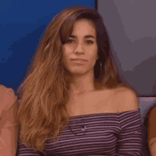 a woman with her eyes closed wearing a striped shirt