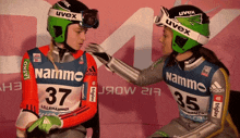 two athletes wearing uvex helmets are talking