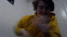 a blurry picture of a man in a yellow sweatshirt