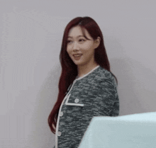 a woman with long red hair is wearing a black and white striped jacket
