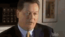 a man in a suit and tie is looking at the camera .