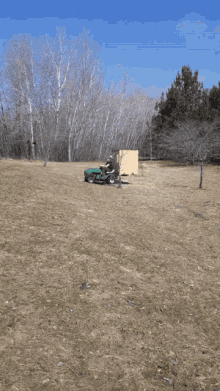 a person riding a lawn mower with a wooden box on it