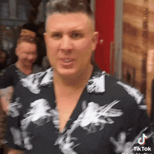 a man wearing a black and white shirt with a tiktok logo on his shirt