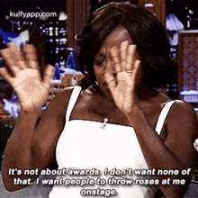 a woman is covering her face with her hands and saying it 's not about awards