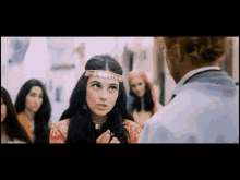 a woman in a headband is talking to a man in a white shirt