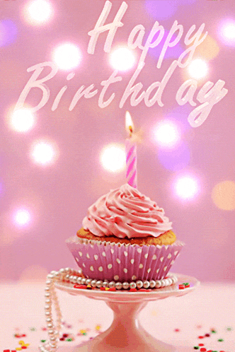 a pink cupcake with a lit candle and the words happy birthday on the bottom