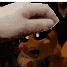 a close up of a puppet wearing sunglasses and a hat .