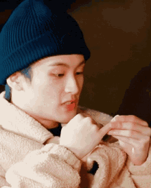 a person wearing a blue beanie and a white jacket