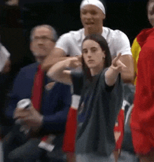 a woman is dancing in the stands at a basketball game while a group of people watch .