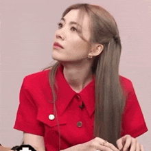 a woman in a red shirt is looking up at the sky
