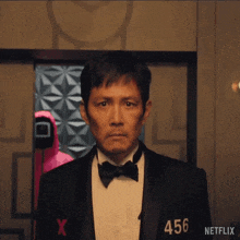 a man in a tuxedo with the number 456 on his shirt .