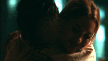 a man and a woman are hugging each other in a dark room