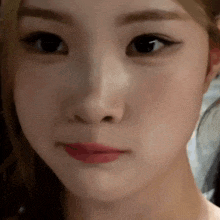 a close up of a woman 's face with a blurred background .