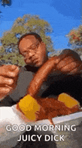 a man is eating a hot dog with a sausage sticking out of his mouth .