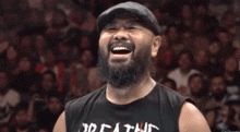 a man with a beard is laughing in front of a crowd wearing a black shirt that says death