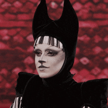 a woman wearing a black and white costume with horns