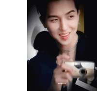 a young man is taking a picture of himself with a polaroid camera