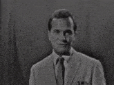 a black and white photo of a man in a suit and white shirt