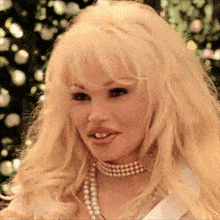 a woman with blonde hair and a pearl choker
