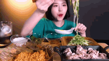 a woman is sitting at a table eating noodles with a spoon