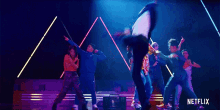 a group of people are dancing on a stage with a netflix logo in the background