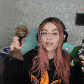a woman with pink hair wearing glasses and headphones