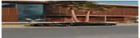 a truck is driving down a street in front of a large building